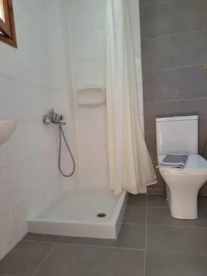 a bathroom with a bath tub next to a toilet at Studios Stavris in Frangokastello