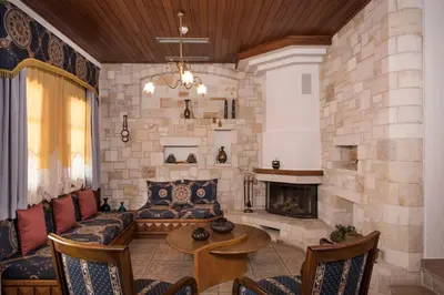 a living room with a couch and a fireplace at Iason Villas – Chania, Crete in Maleme