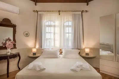 a bedroom with a bed with two pillows and a window at Iason Villas – Chania, Crete in Maleme