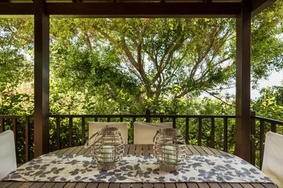 a table and chairs on a deck with a tree at Iason Villas – Chania, Crete in Maleme