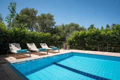 a swimming pool with two lounge chairs and a swimming pool at Iason Villas – Chania, Crete in Maleme
