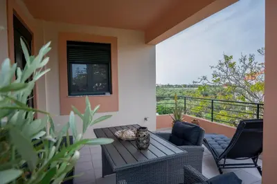 a patio with a table and chairs on a balcony at Helen Sweet Home in Kounoupidhianá