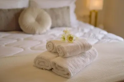a pile of towels sitting on top of a bed at Helen Sweet Home in Kounoupidhianá