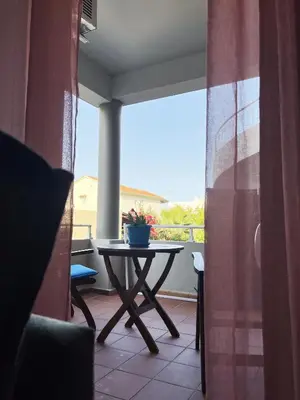 a table on a balcony with a view of a patio at Anna's Apartment in Kato Daratso