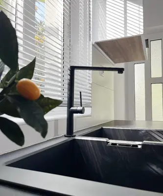 a kitchen sink with a faucet next to a plant at Anna's Apartment in Kato Daratso