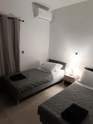 a bedroom with two beds and a lamp on a table at Vrachakia Stylish in Ayiá