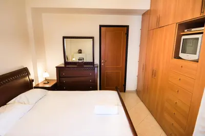 a bedroom with a bed and a dresser and a television at Electra's House in Chania Town