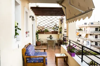 a balcony with a table and chairs and a window at Electra's House in Chania Town