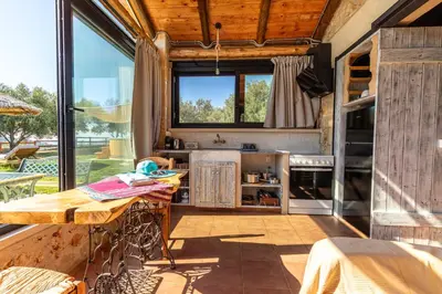 a kitchen with a table and a large window at Villa Fabrica Baladakis adults only in Metókhi