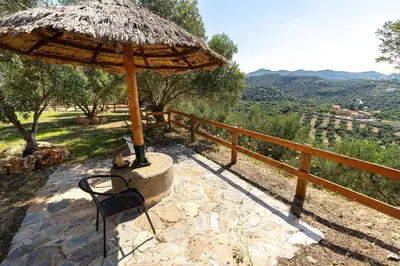 a patio with a chair and an umbrella at Villa Fabrica Baladakis adults only in Metókhi