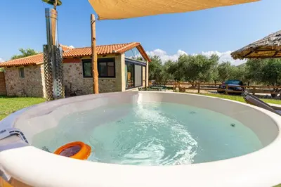 a large hot tub in a yard with a house at Villa Fabrica Baladakis adults only in Metókhi