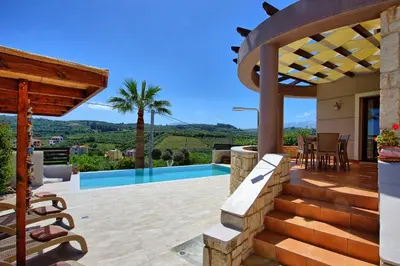 a villa with a view of a house with a patio at Villa Kostantina by PosarelliVillas in Plaka