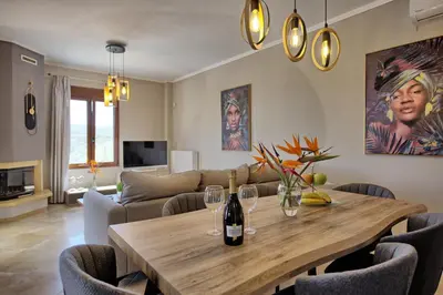 a living room with a wooden table with wine bottles at Villa Kostantina by PosarelliVillas in Plaka