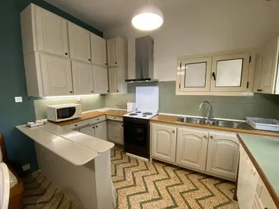 a kitchen with white cabinets and a sink and a stove at Efi’s House in Chania Town