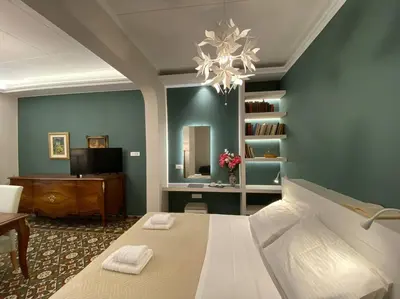 a bedroom with a bed and a desk and a chandelier at Efi’s House in Chania Town