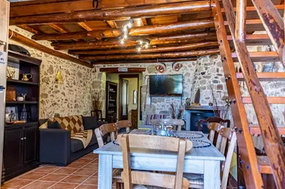 a kitchen and living room with a table and chairs at Traditional Mansion in Kaláthenai