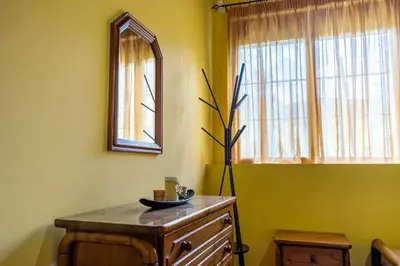 a room with a mirror and a dresser and a window at Traditional Mansion in Kaláthenai