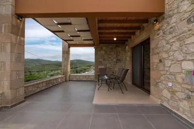 a balcony of a house with a table and chairs at Lithina charm villa with private pool and sea view in Kamisianá