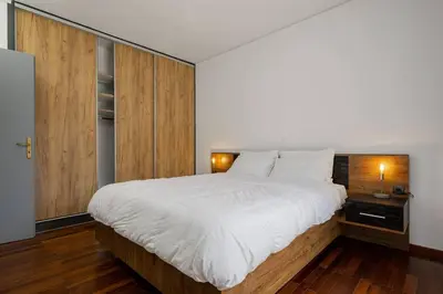 a bedroom with a large white bed and wooden cabinets at Stefanos apartment Chania in Chania Town