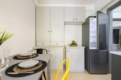 a kitchen with white cabinets and a table with dishes on it at Stefanos apartment Chania in Chania Town