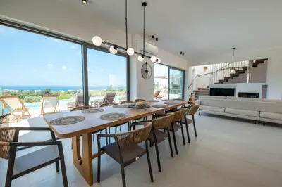 a dining room with a long table and chairs at Star Luxury Villa - Private pool, gym, playground in Kato Daratso
