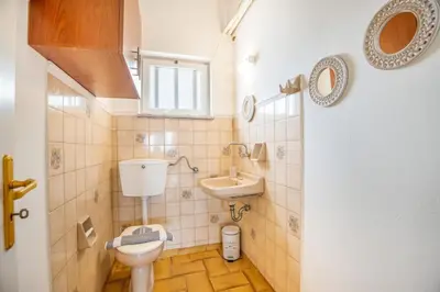 a small bathroom with a toilet and a sink at Ortansia House near the Sea in Ayiá