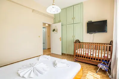 a room with a crib and a tv and a crib at Ortansia House near the Sea in Ayiá