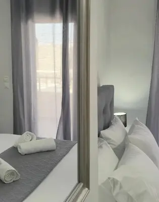 a mirror reflection of a bed with towels on it at Idene Penthouse in Chania Town