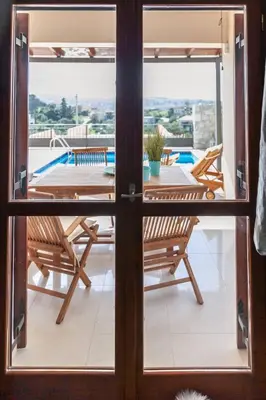 a view from the door of a patio with a table and chairs at Vila Vasiliki, Next To Platanias, 6min From Sea in Vrísai