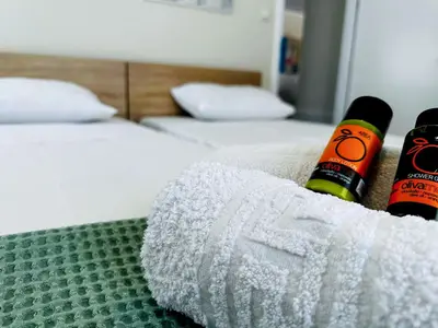 a bed with two beds with towels on it at lifeguard beachfront - Luxury Flat, 30meters From Sea in Stalos