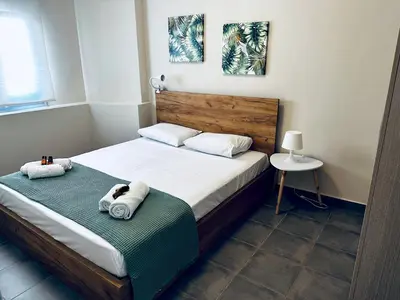 a bedroom with a bed with towels on it at lifeguard beachfront - Luxury Flat, 30meters From Sea in Stalos