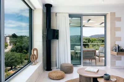 a living room with a large window and a table at Heniochos Villas in Chania Town