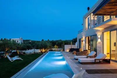 a swimming pool in the backyard of a house at Heniochos Villas in Chania Town