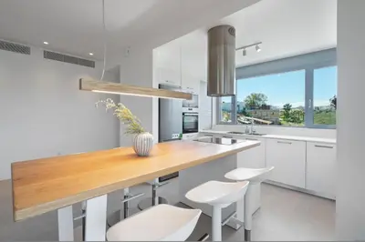 a kitchen with a wooden counter and white cabinets at Le Mont Blanc - with shared Pool in Kounoupidhianá
