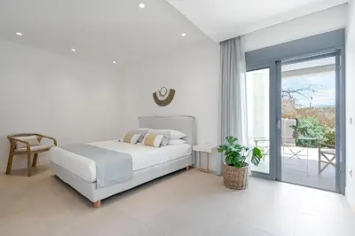 a white bedroom with a bed and a balcony at Le Mont Blanc - with shared Pool in Kounoupidhianá