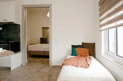 a room with a bed and a bedroom with a window at Sia's Sea House in Almirida