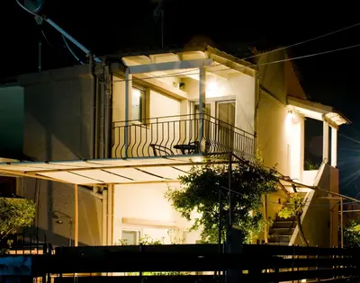 a white house with a balcony at night at Sia's Sea House in Almirida