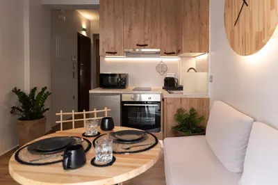 a small kitchen with a table and a dining room at Anassa Seaside Residence- 50m from Sandy Beach in Chania Town