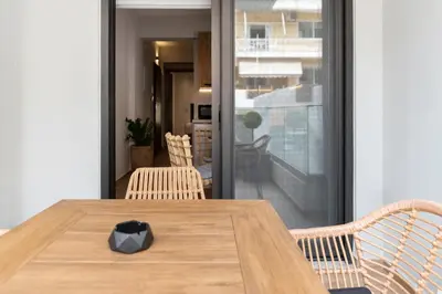 a wooden table with two chairs and a dining room at Anassa Seaside Residence- 50m from Sandy Beach in Chania Town