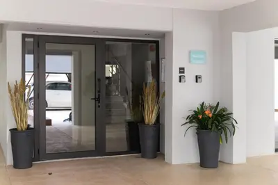 a lobby with three potted plants in front of a door at Anassa Seaside Residence- 50m from Sandy Beach in Chania Town
