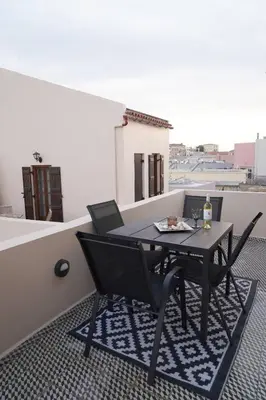 a black table and chairs on a balcony at Venetian Owl, 1min To Lighthouse in Chania Town