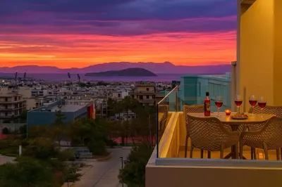 a balcony with a table with wine glasses and a sunset at A Heaven View Park Hideaway - Chania Nest in Chania Town