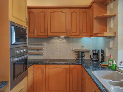 a kitchen with wooden cabinets and a sink at Lemon Tree Villa with Private Pool and Starlink Internet in Frés