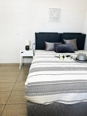 a large bed with a black and white blanket on it at Cozy Snuggle- 2min To Beach, 6min Walk To Old Town in Chania Town