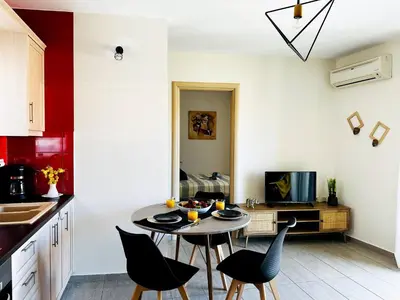a kitchen with a table and chairs in a room at Cozy Snuggle- 2min To Beach, 6min Walk To Old Town in Chania Town