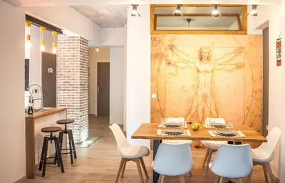 a dining room with a table with chairs and a painting on the wall at Secret Loft, 2min Walk From The Beach, High Tech in Chania Town