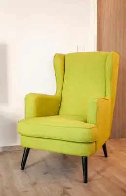 a yellow chair sitting in a living room at Secret Loft, 2min Walk From The Beach, High Tech in Chania Town