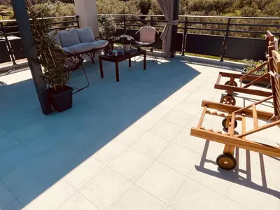 a patio with chairs and tables on a balcony at Phaedra House For Relaxing Holidays Near Platanias in Vlakheronítissa
