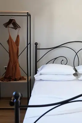a bed with a black frame with a dress on a shelf at The Suite Spot - At The Heart Of The Old Town in Chania Town