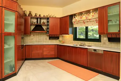 a kitchen with wooden cabinets and a sink and a window at Koralia - Chanias Card Postal Villa Majestic View in Chania Town